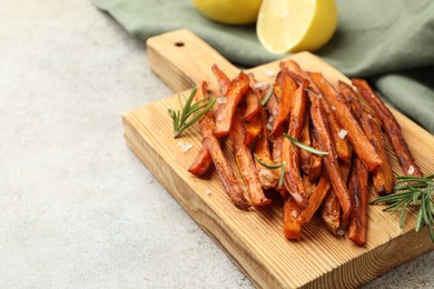 Photo of Delicious sweet potato fries with spices on grey table, closeup. Space for text