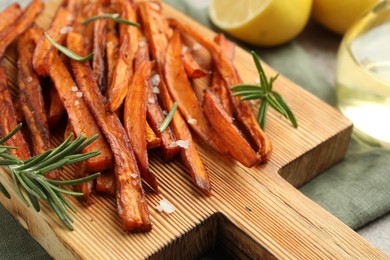 Photo of Delicious sweet potato fries with spices on table, closeup