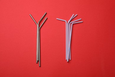 Photo of Plastic and metal drinking straws on red background, top view