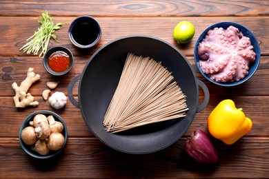 Different ingredients for wok on wooden table, flat lay