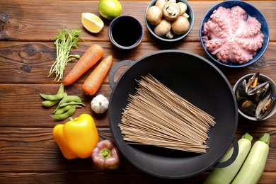 Different ingredients for wok on wooden table, flat lay