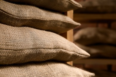 Photo of Group of burlap sacks on shelving unit indoors, closeup