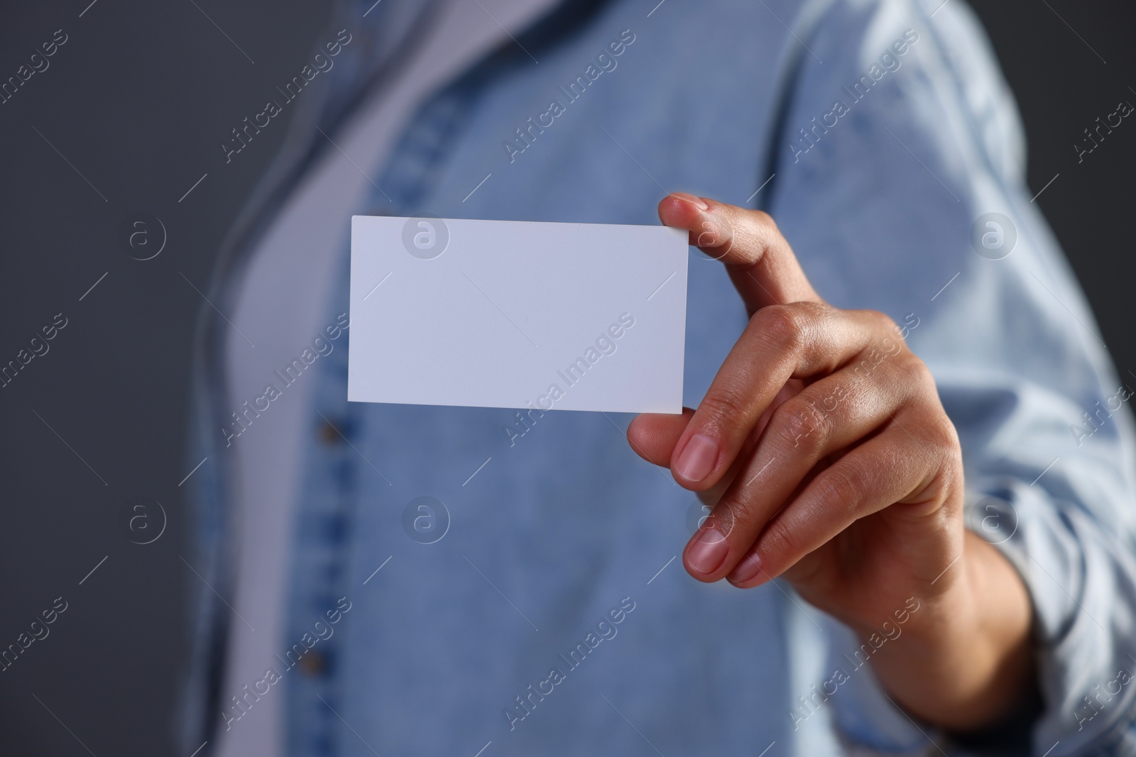 Photo of Woman holding blank business card on grey background, closeup. Mockup for design