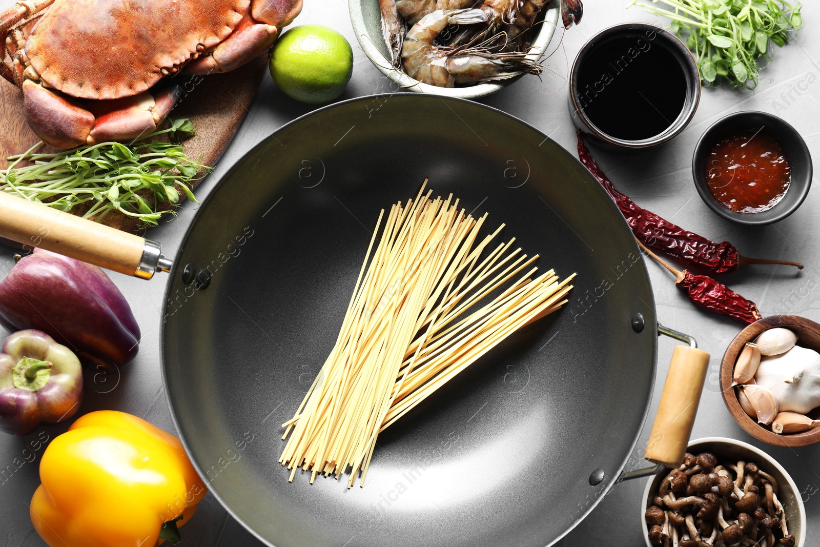 Photo of Different ingredients for wok on light grey table, flat lay