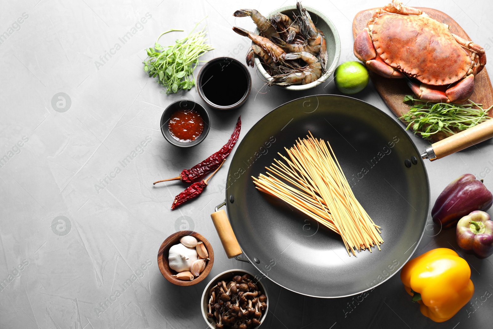 Photo of Different ingredients for wok on light grey table, flat lay