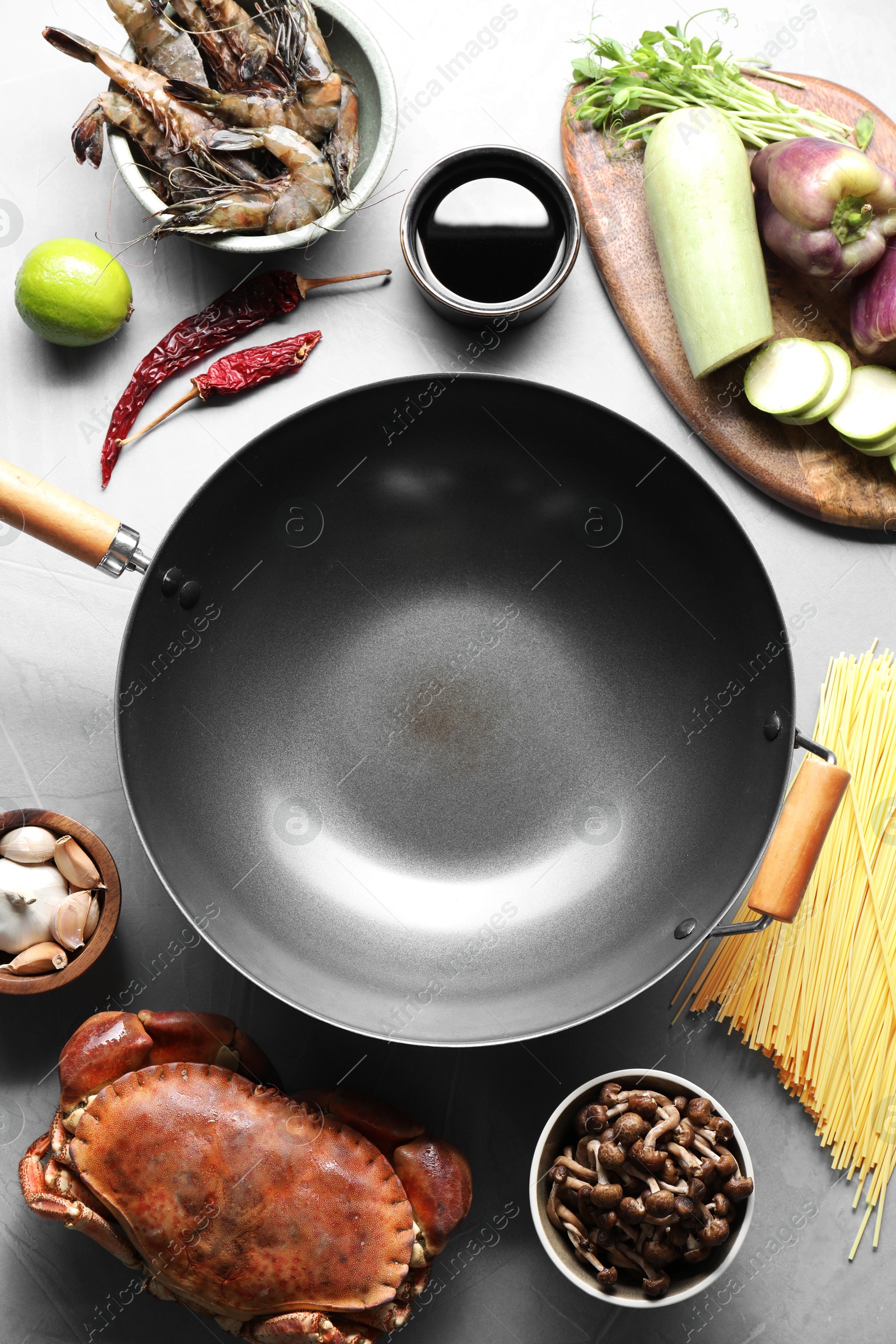 Photo of Different ingredients for wok on light grey table, flat lay