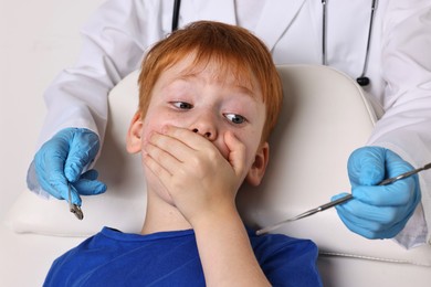 Dental phobia. Dentist working with scared little boy