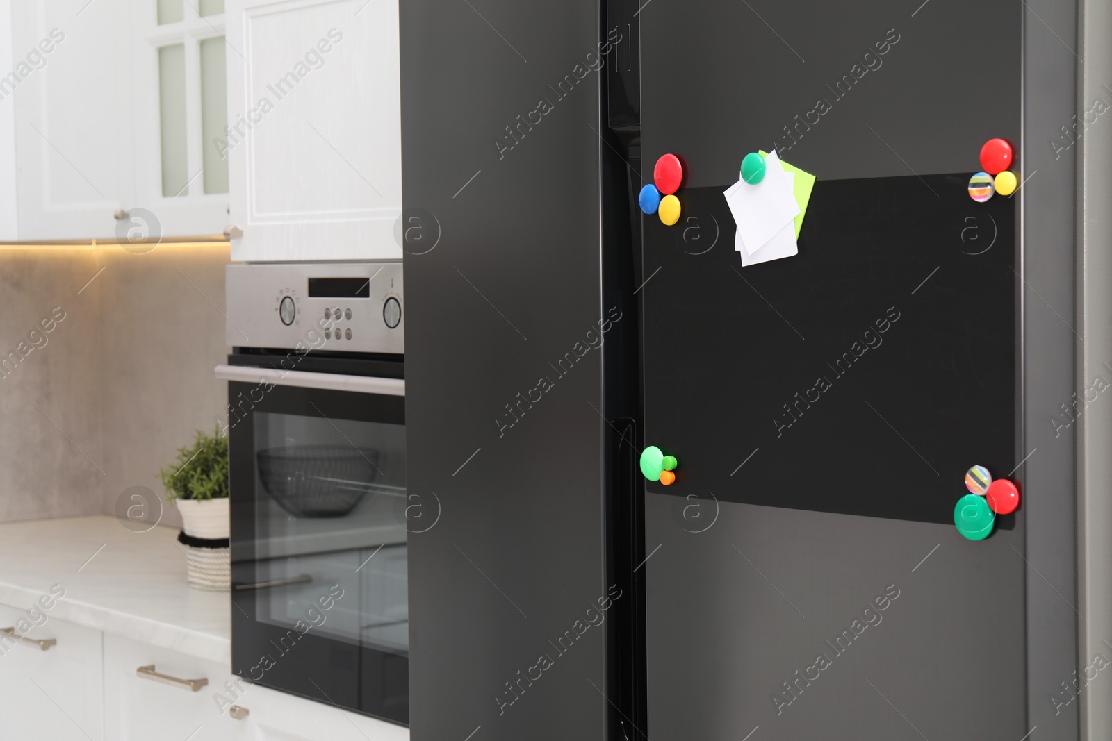 Photo of Blank magnetic board with notes on refrigerator in kitchen