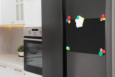 Photo of Blank magnetic board with notes on refrigerator in kitchen