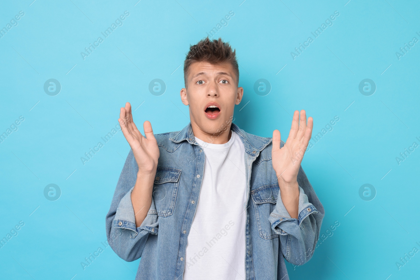 Photo of Portrait of scared young man on light blue background