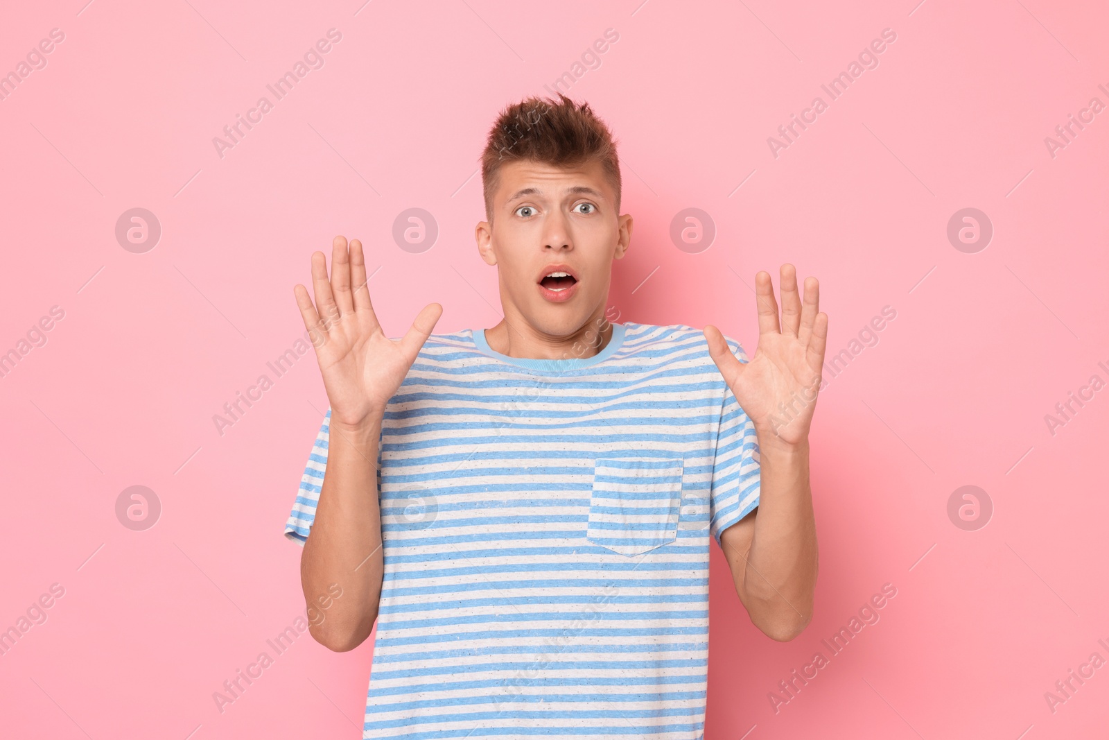 Photo of Portrait of scared young man on pink background