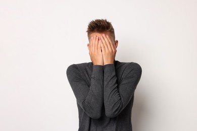 Portrait of scared young man on light background