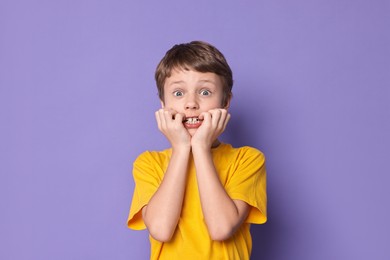 Photo of Portrait of scared little boy on violet background