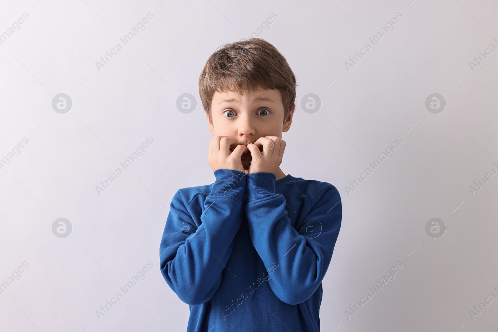 Photo of Portrait of scared little boy on light background