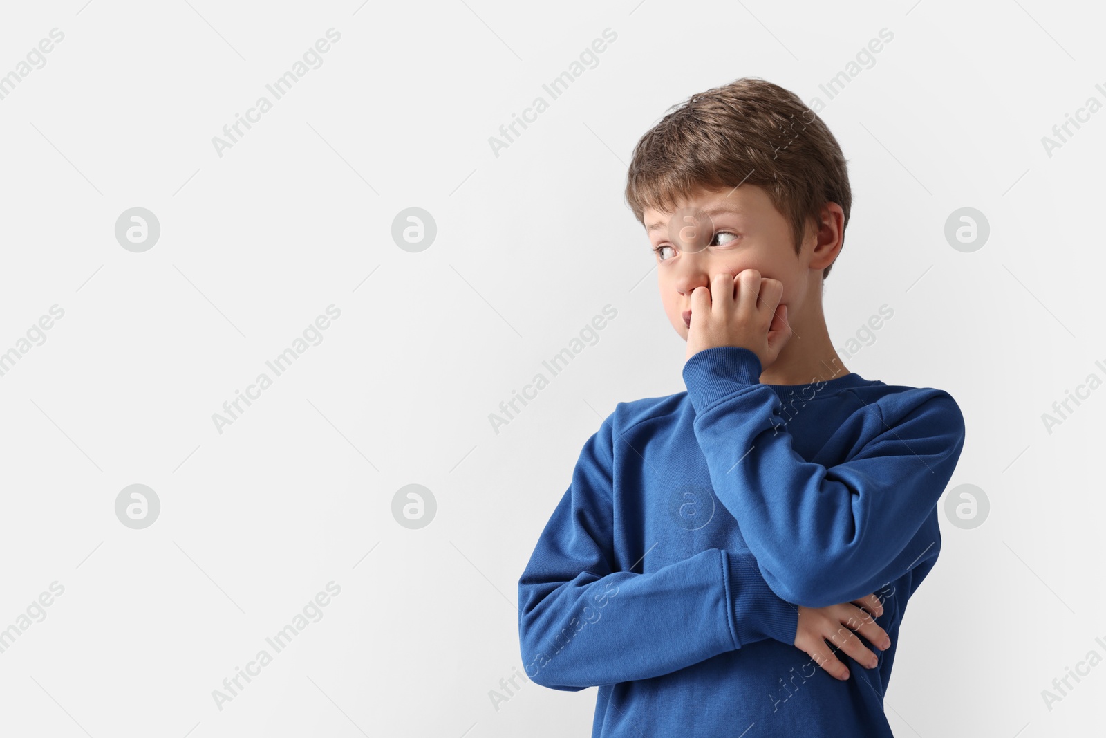 Photo of Scared little boy on light background. Space for text