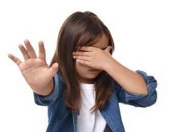 Scared little girl covering eyes with hands on white background