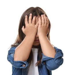 Scared little girl covering face with hands on white background