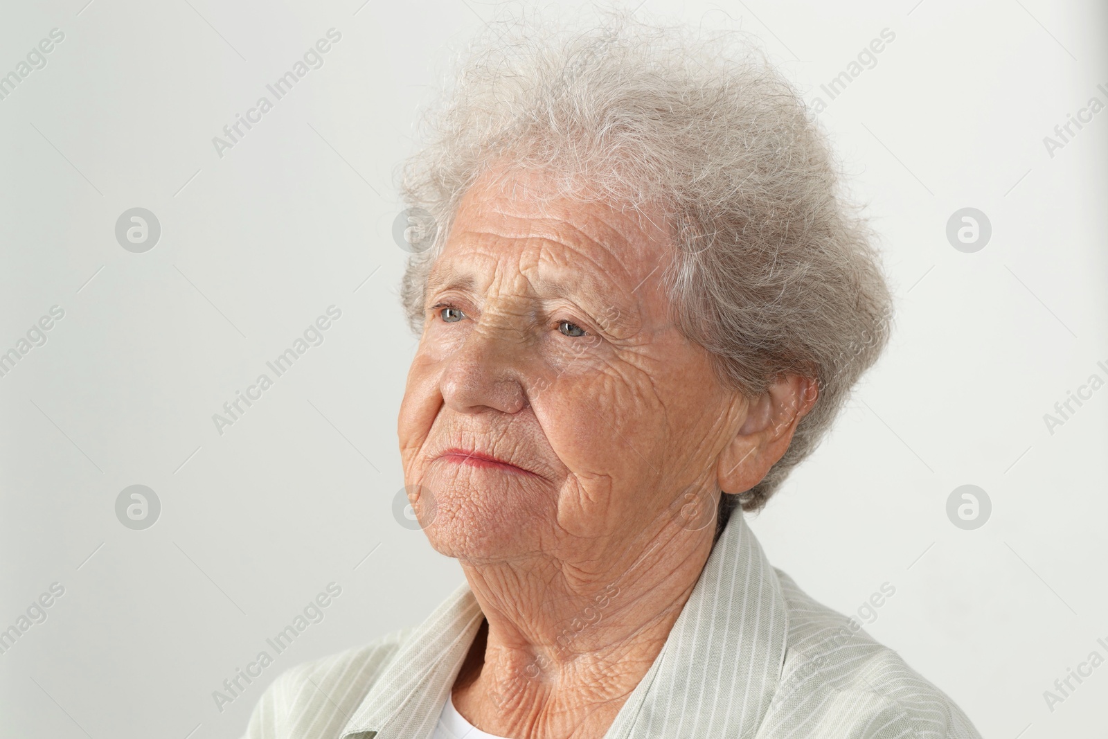 Photo of Portrait of senior woman on light grey background, closeup