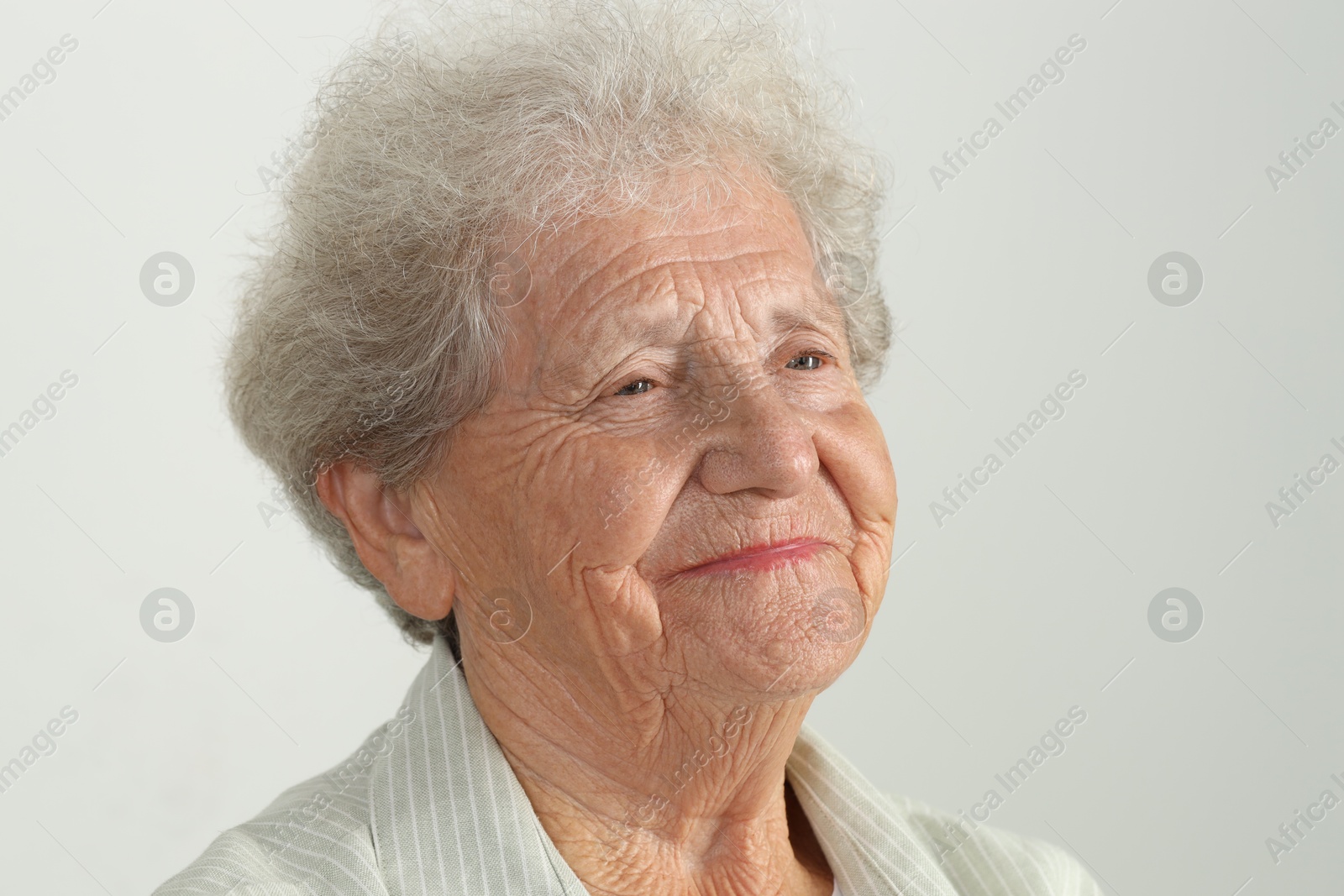 Photo of Portrait of senior woman on light grey background, closeup