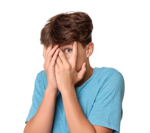 Scared teenage boy covering face with hands on white background