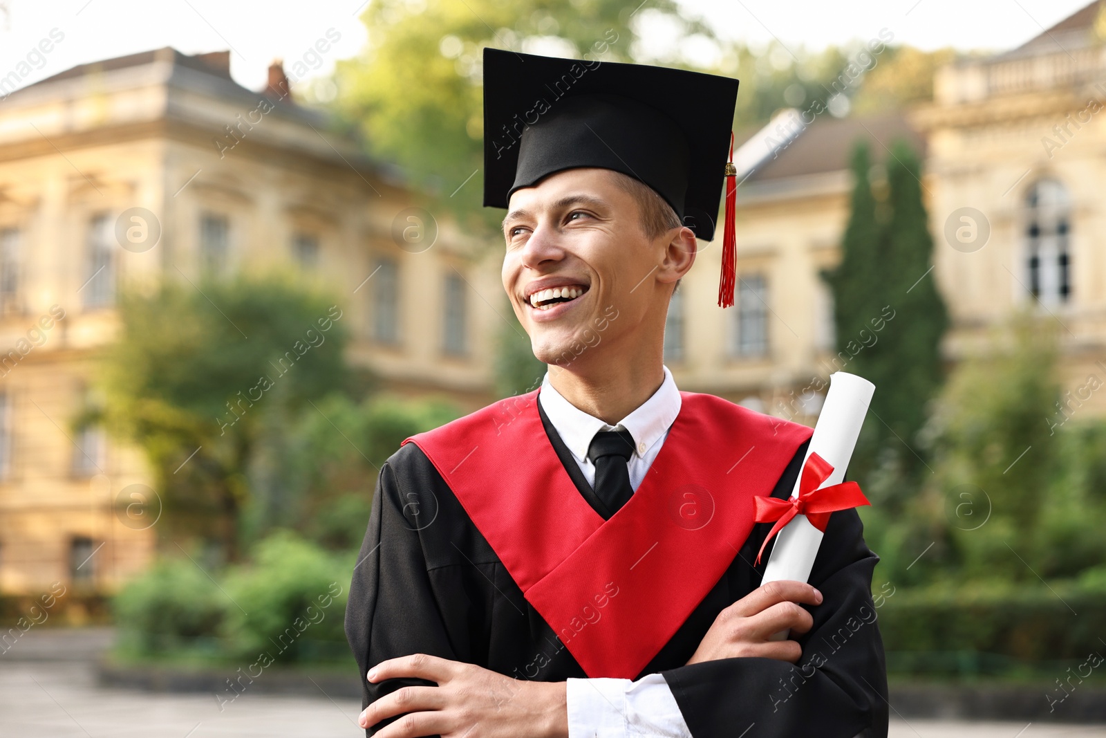 Photo of Happy student with diploma after graduation ceremony outdoors