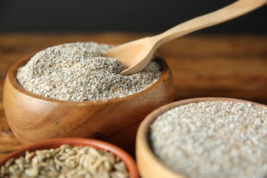 Photo of Fresh rye bran in bowls and spoon on table, closeup