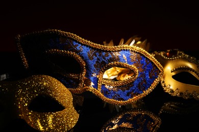 Photo of Beautiful blue carnival mask on black background, closeup