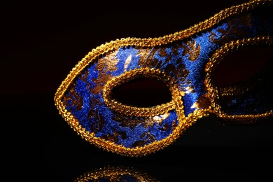 Photo of Beautiful blue carnival mask on black background, closeup