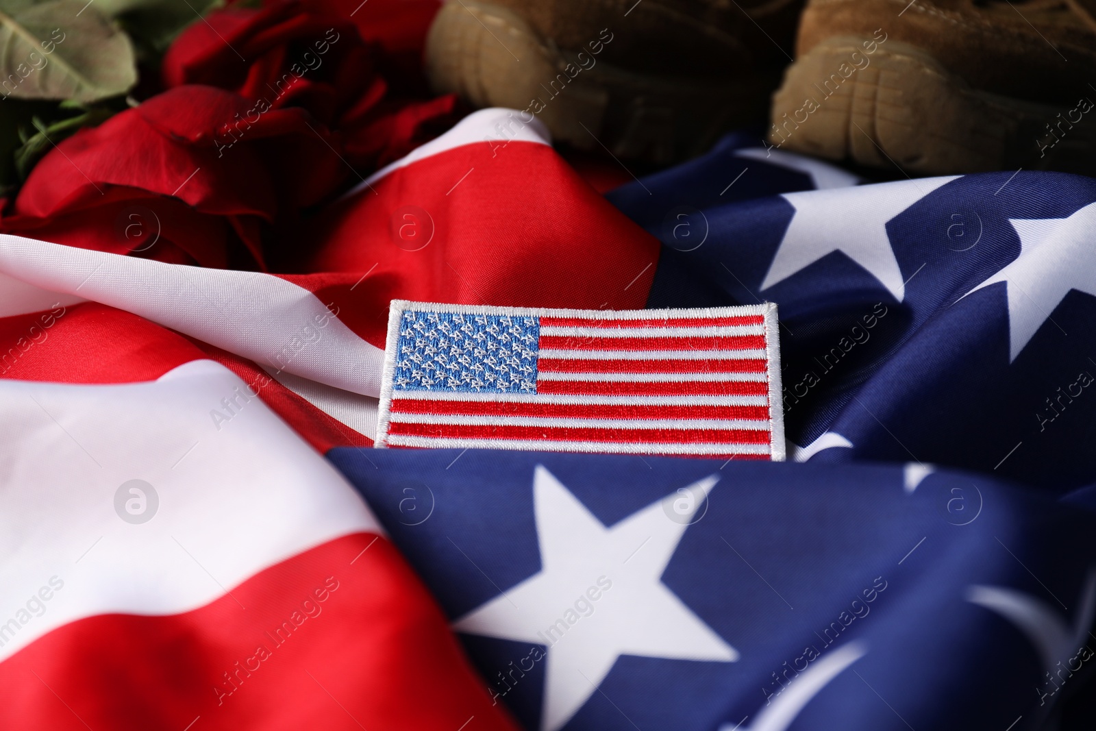 Photo of Veterans day. USA army patch, American flag, roses and military shoes, closeup