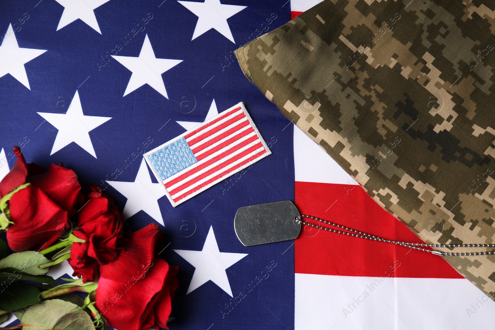 Photo of Veterans day. USA army patch, token, American flag, roses and military uniform, flat lay