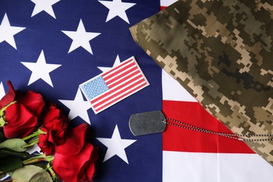 Photo of Veterans day. USA army patch, token, American flag, roses and military uniform, flat lay