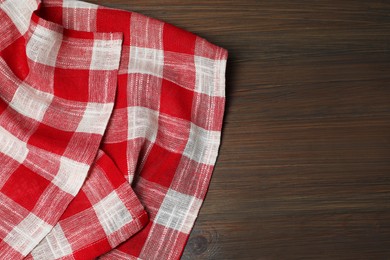 Crumpled tablecloth with checkered pattern on wooden table, top view. Space for text