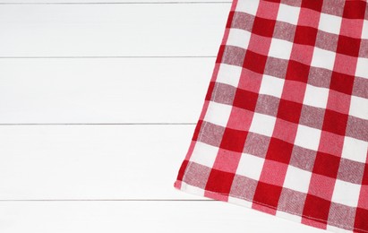 Photo of Tablecloth with checkered pattern on white wooden table, top view. Space for text