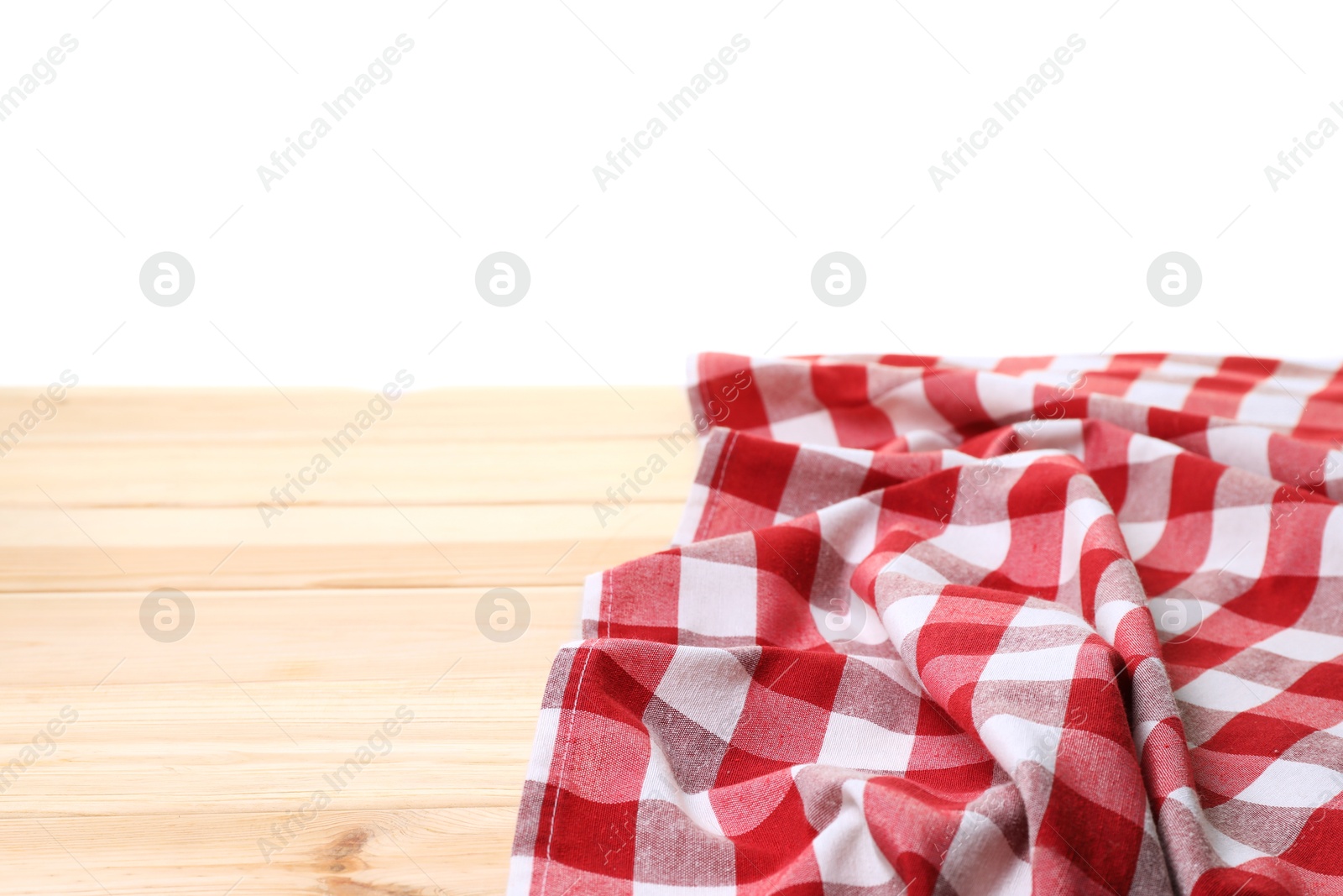 Photo of Crumpled tablecloth with checkered pattern on light wooden table against white background