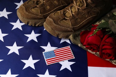 Photo of Veterans day. USA army patch, American flag, roses and military uniform, above view