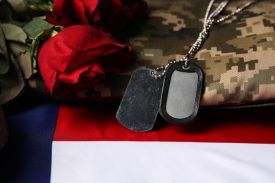 Photo of Veterans day. Army tokens, American flag, roses and military uniform, closeup