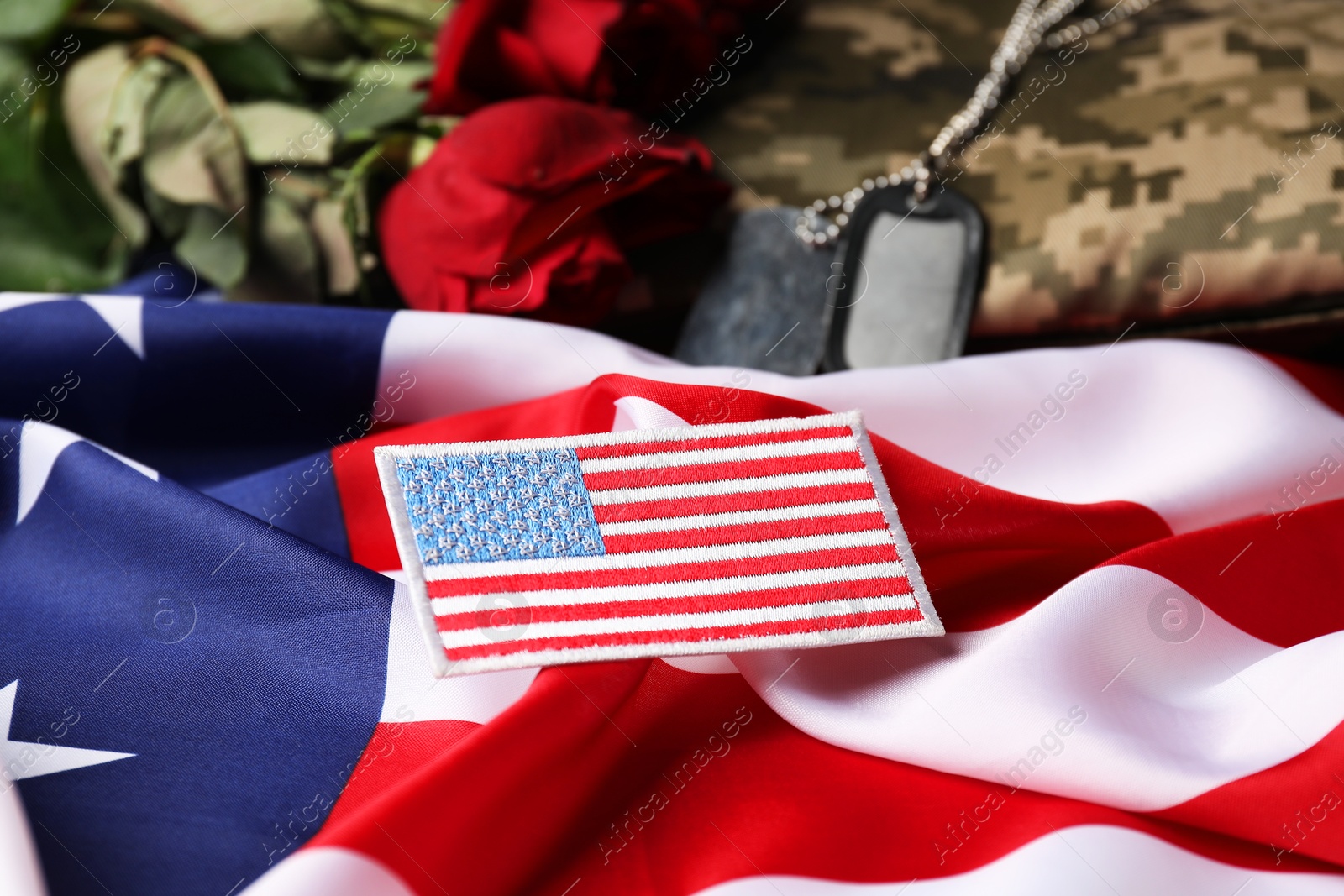 Photo of Veterans day. USA army patch, tokens, American flag, roses and military uniform, closeup