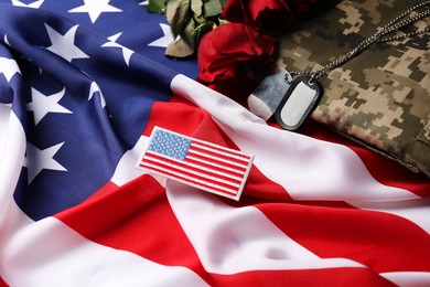 Photo of Veterans day. USA army patch, tokens, American flag, roses and military uniform, closeup