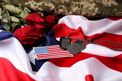 Photo of Veterans day. USA army patch, tokens, American flag, roses and military uniform, closeup