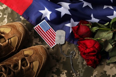 Photo of Veterans day. USA army patch, token, American flag, roses and military uniform, flat lay