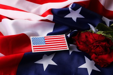 Photo of Veterans day. USA army patch, American flag and roses, closeup