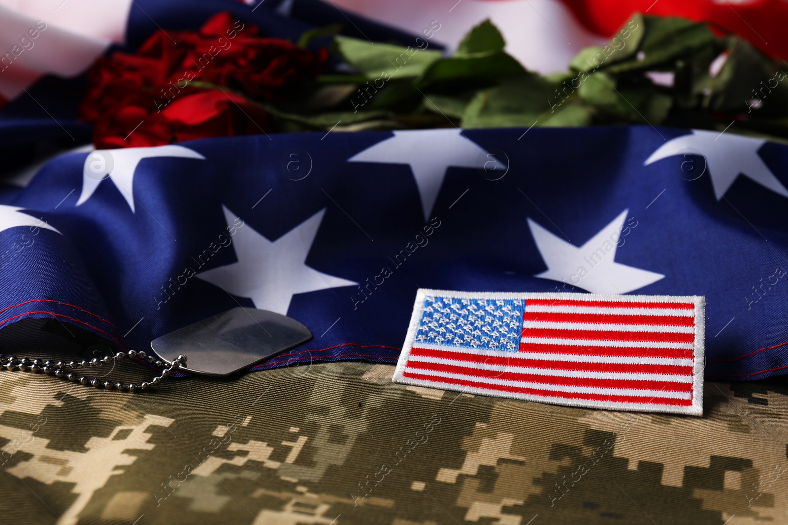 Photo of Veterans day. USA army patch, token, American flag, roses and military uniform, closeup