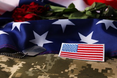 Veterans day. USA army patch, token, American flag, roses and military uniform, closeup