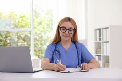 Doctor with clipboard at table in clinic