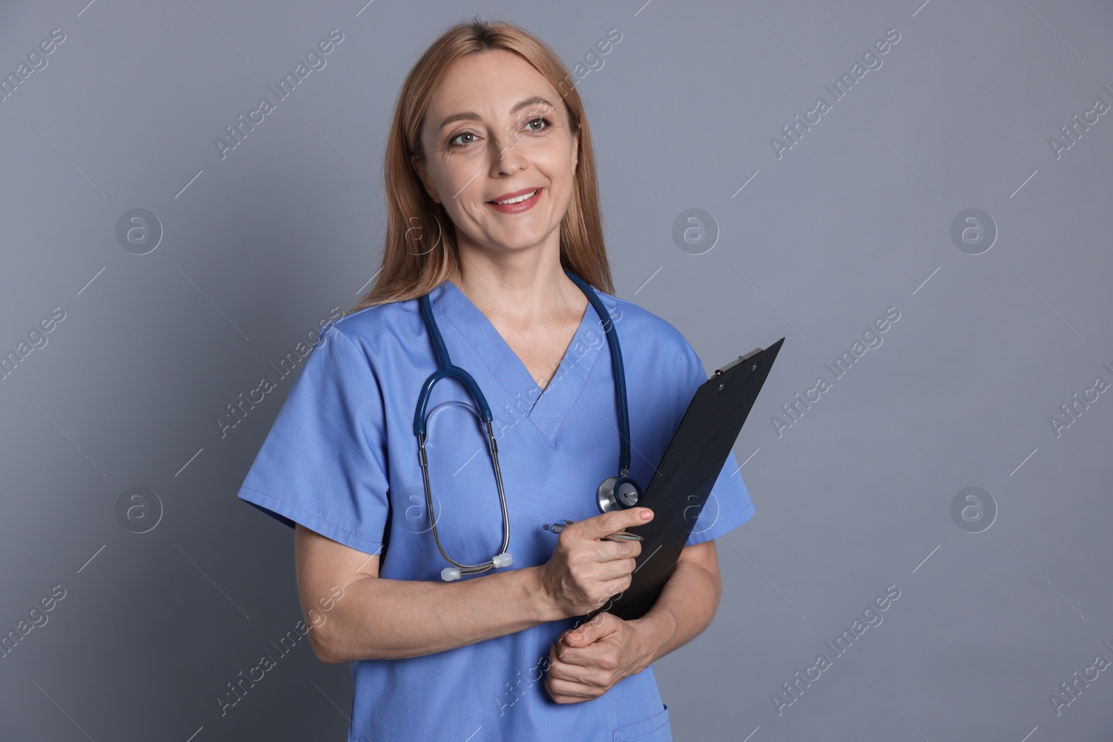 Photo of Doctor with stethoscope and clipboard on gray background