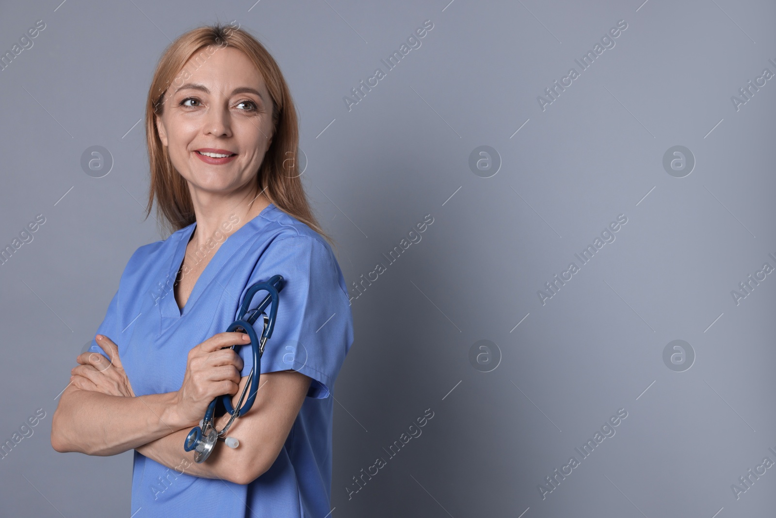 Photo of Doctor with stethoscope on gray background, space for text