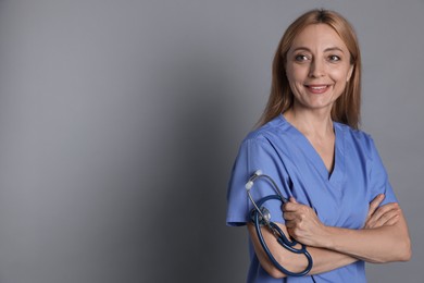 Photo of Doctor with stethoscope on gray background, space for text