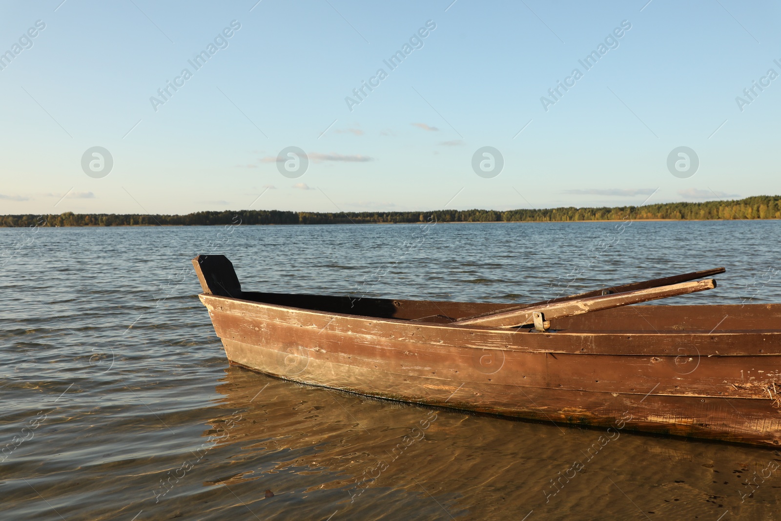 Photo of Empty wooden boat with oars on river