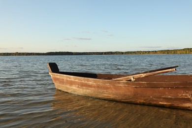 Photo of Empty wooden boat with oars on river