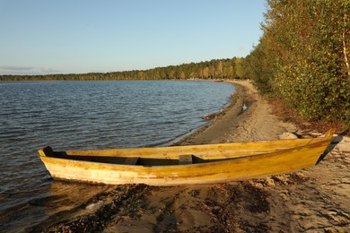 Photo of Wooden boat near river on sunny day